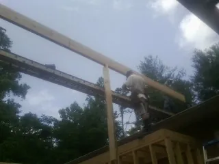 Carpenter setting a ridge beam over a new addition frame — Ice Dam Removal by Roofing Brothers in Olsburg